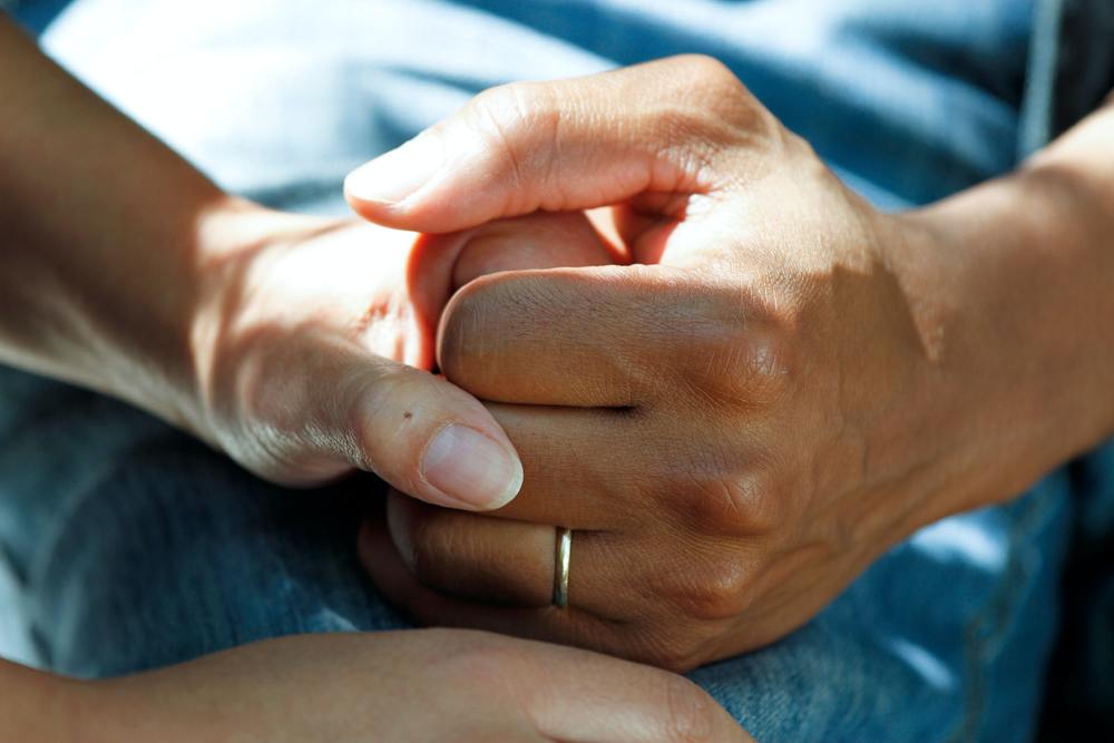 Begleitende Unterstützung bei Krebs – CBD in der komplementären Therapie Nahaufnahme zweier sich haltender Hände – Symbol für Mitgefühl, Unterstützung und begleitende Pflege bei Krebserkrankungen