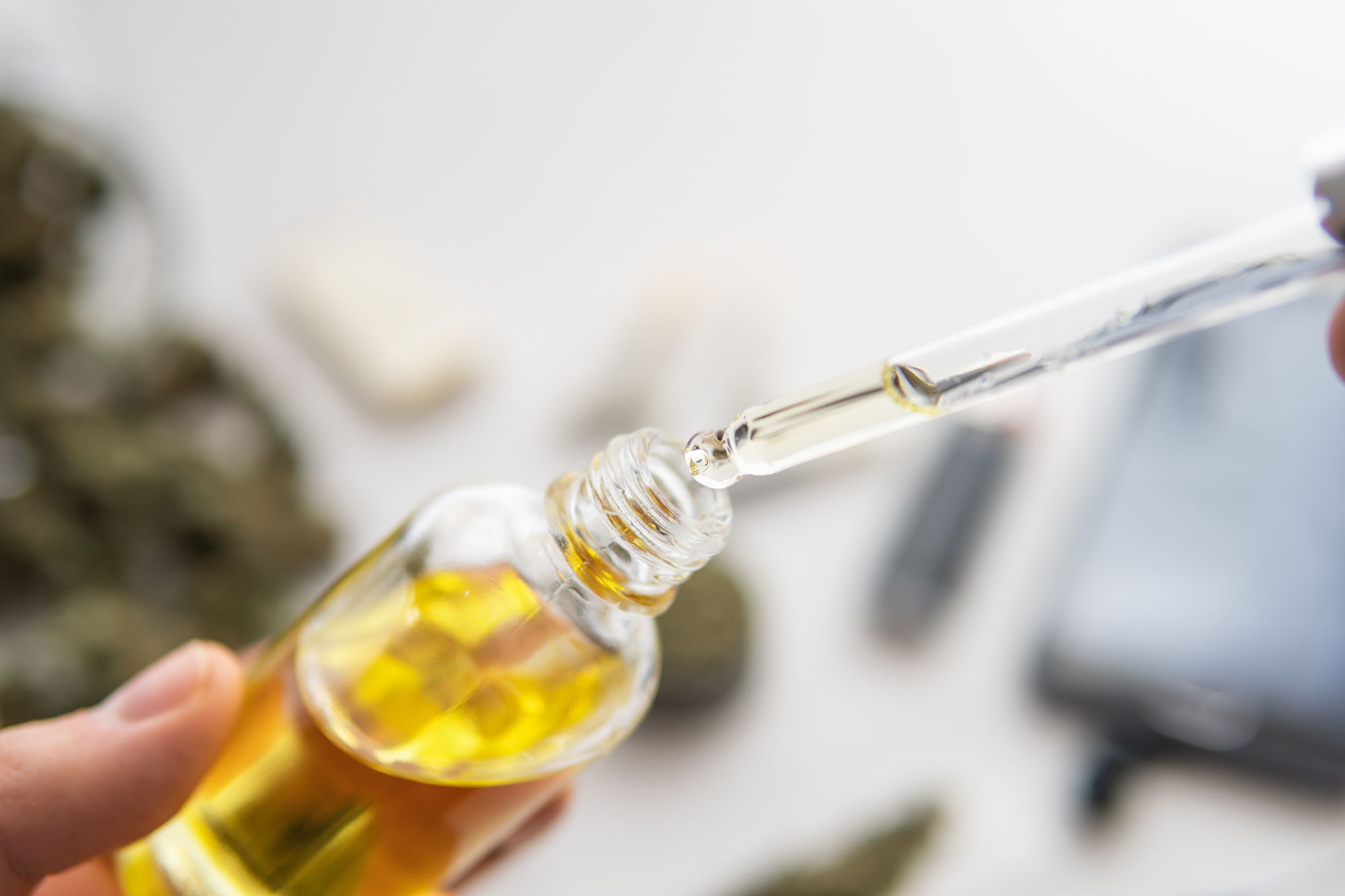 Kann man CBD überdosieren? – Wissenswertes zur sicheren Anwendung von Cannabidiol Pipette mit CBD-Öl über einer geöffneten Flasche – Symbolbild für Dosierung und mögliche Risiken einer Überdosierung von Cannabidiol