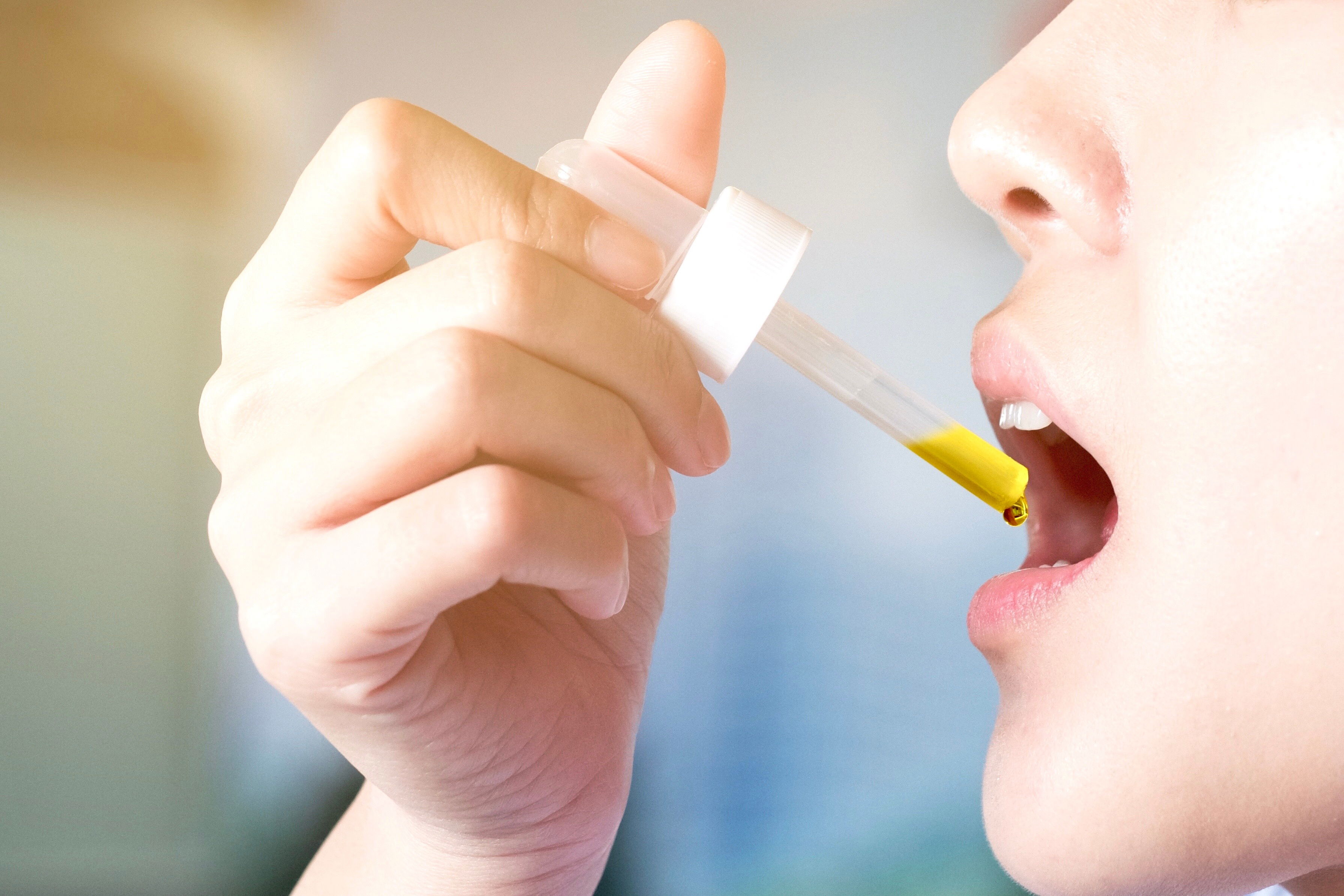 Frau nimmt mit einer Pipette CBD Öl oral ein als tägliche Routine