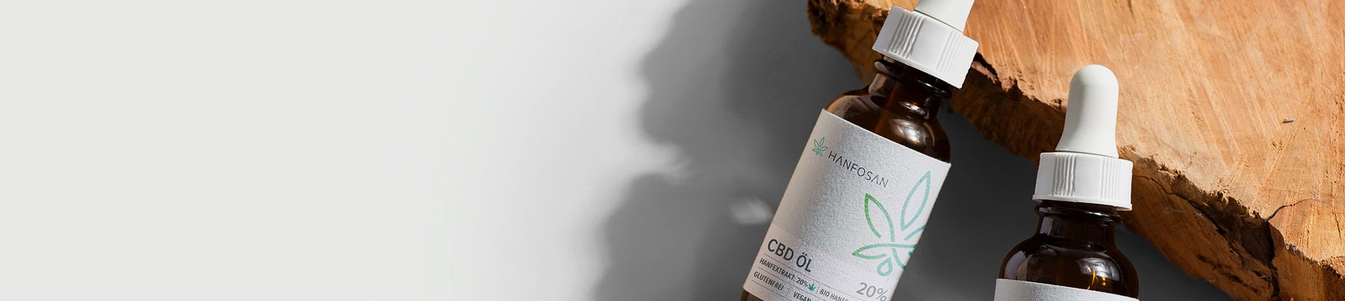Hanfosan CBD-Öl – Natürlichkeit in jeder Flasche Zwei Flaschen Hanfosan CBD-Öl auf natürlichem Holzuntergrund