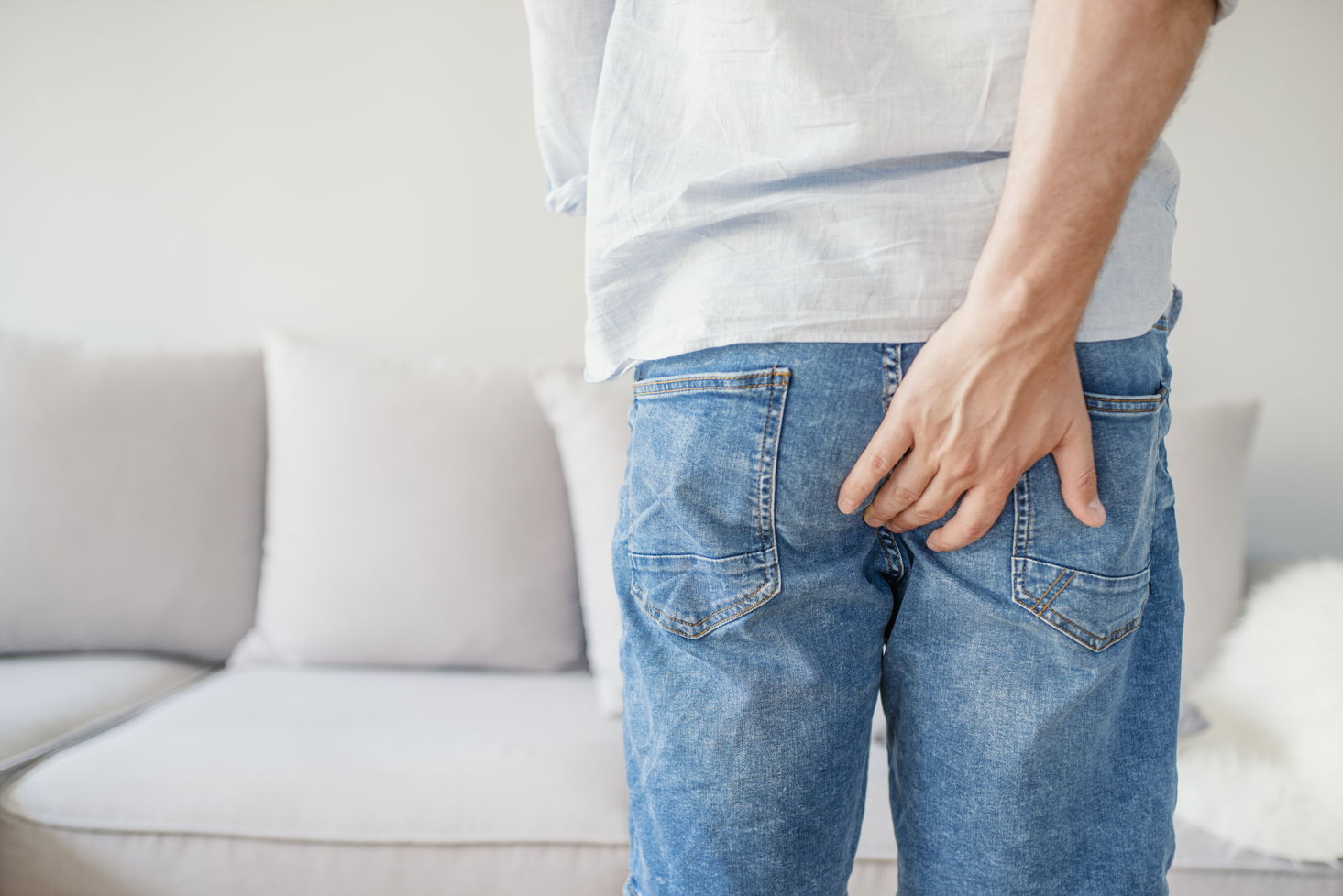 CBD gegen Hämorrhoiden – Natürliche Hilfe bei Juckreiz, Schmerzen und Entzündungen Mann greift sich diskret an das Gesäß – Symbolbild für Beschwerden durch Hämorrhoiden und mögliche Linderung durch CBD
