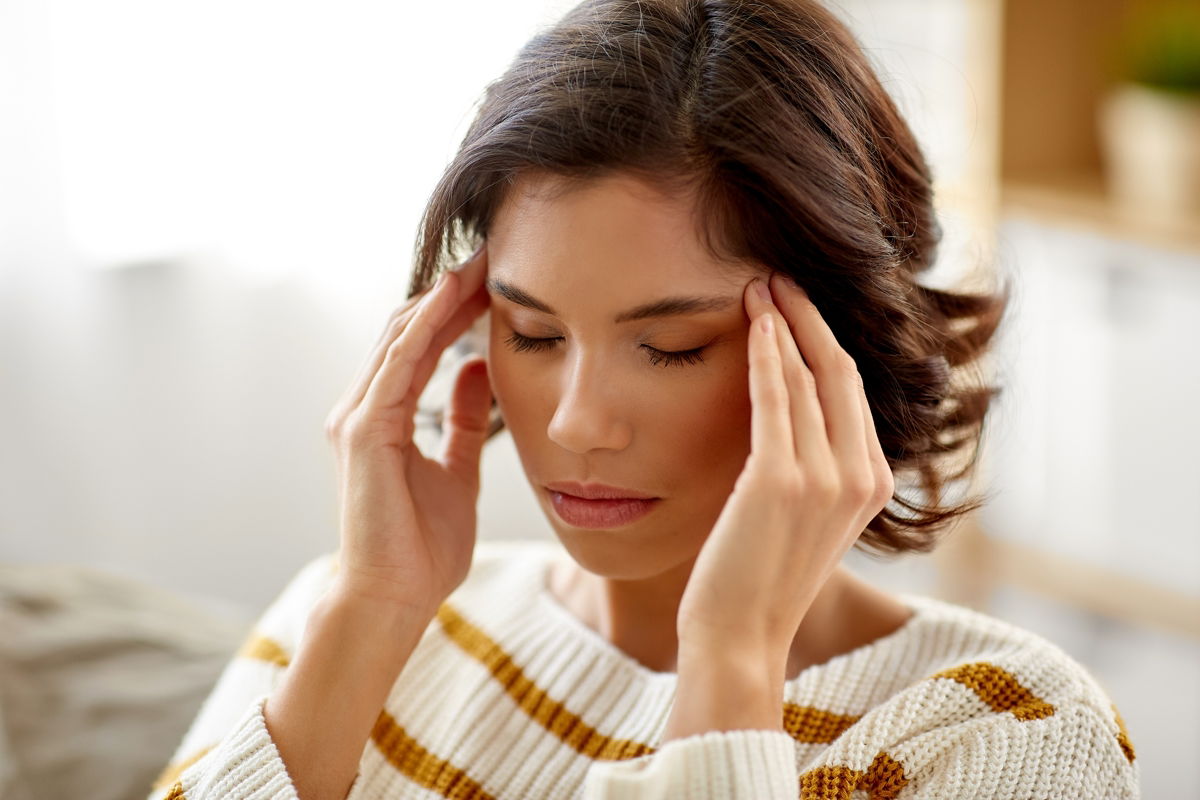 Stressbewältigung mit CBD – Natürliche Unterstützung im Alltag Junge Frau hält sich gestresst den Kopf – CBD als Hilfe zur Stressreduktion im Alltag